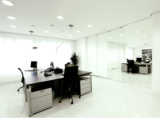 Clean and spacious office with white walls and mirrors.