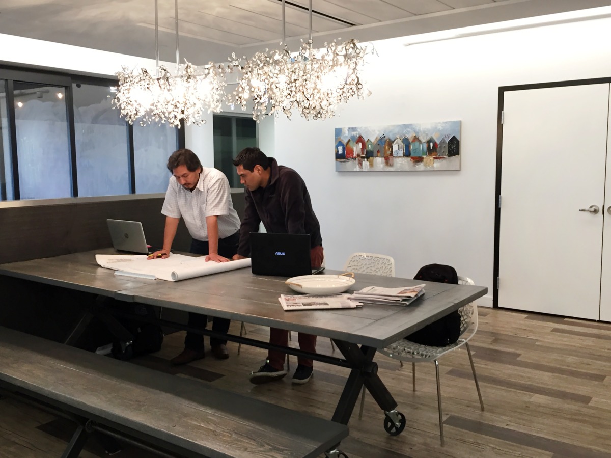 Two colleagues looking at documents together in a conference room.