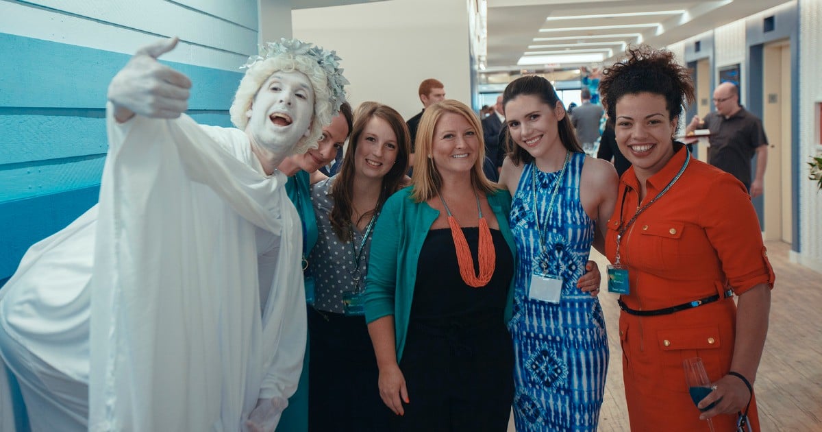 Group of colleagues posing for a photo with a costumed person.