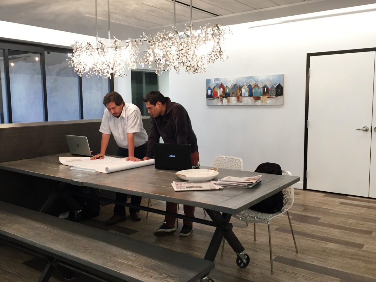 Large table with two people reading documents.