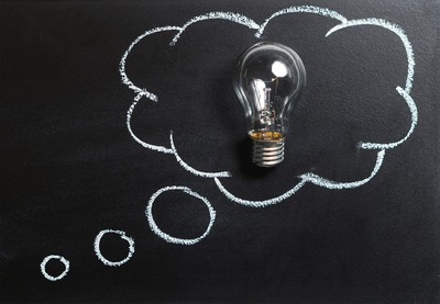 Lightbulp within a drawn cloud on a chalkboard