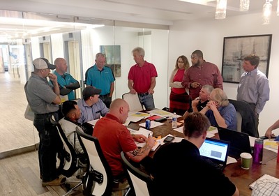 Group of people meeting around a conference table.