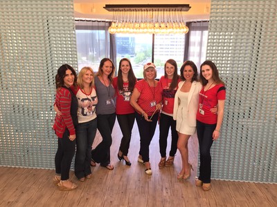 Group of woman standing together smiling.