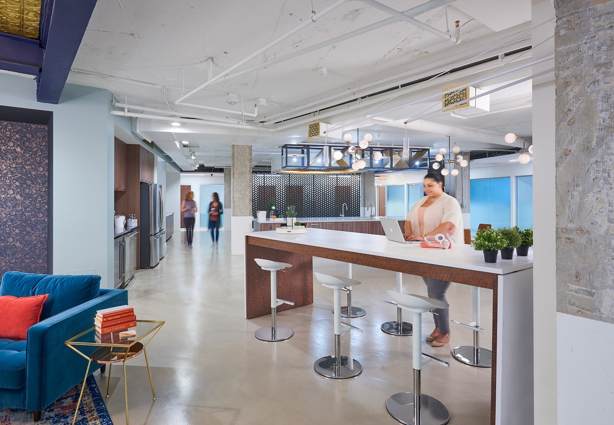 Open office space with counter desks and kitchen area.