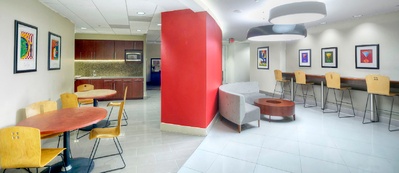 Office space with tables, chairs and couch.