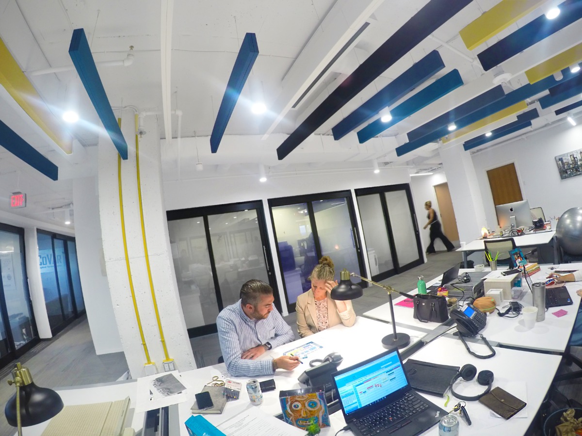 Open office space with two people working at a desk.